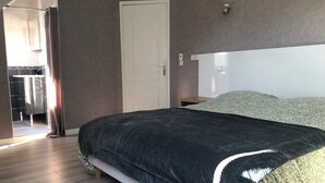 Ein Schlafzimmer mit Bett, einer Tür und einer Dusche.