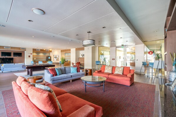 A spacious lobby with a seating area, a dining area, and a kitchen visible in the background. - PackHouse NRG/MED Center (Houston)