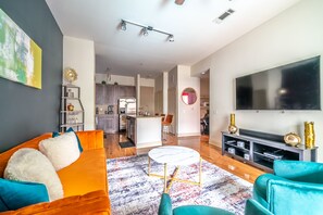 Un salon moderne avec un canapé, une table basse et un téléviseur.
