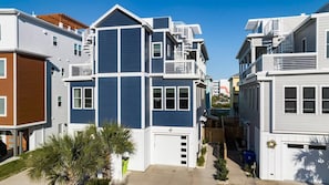 A modern multi-story residential building with a central courtyard, balconies, and a garage.