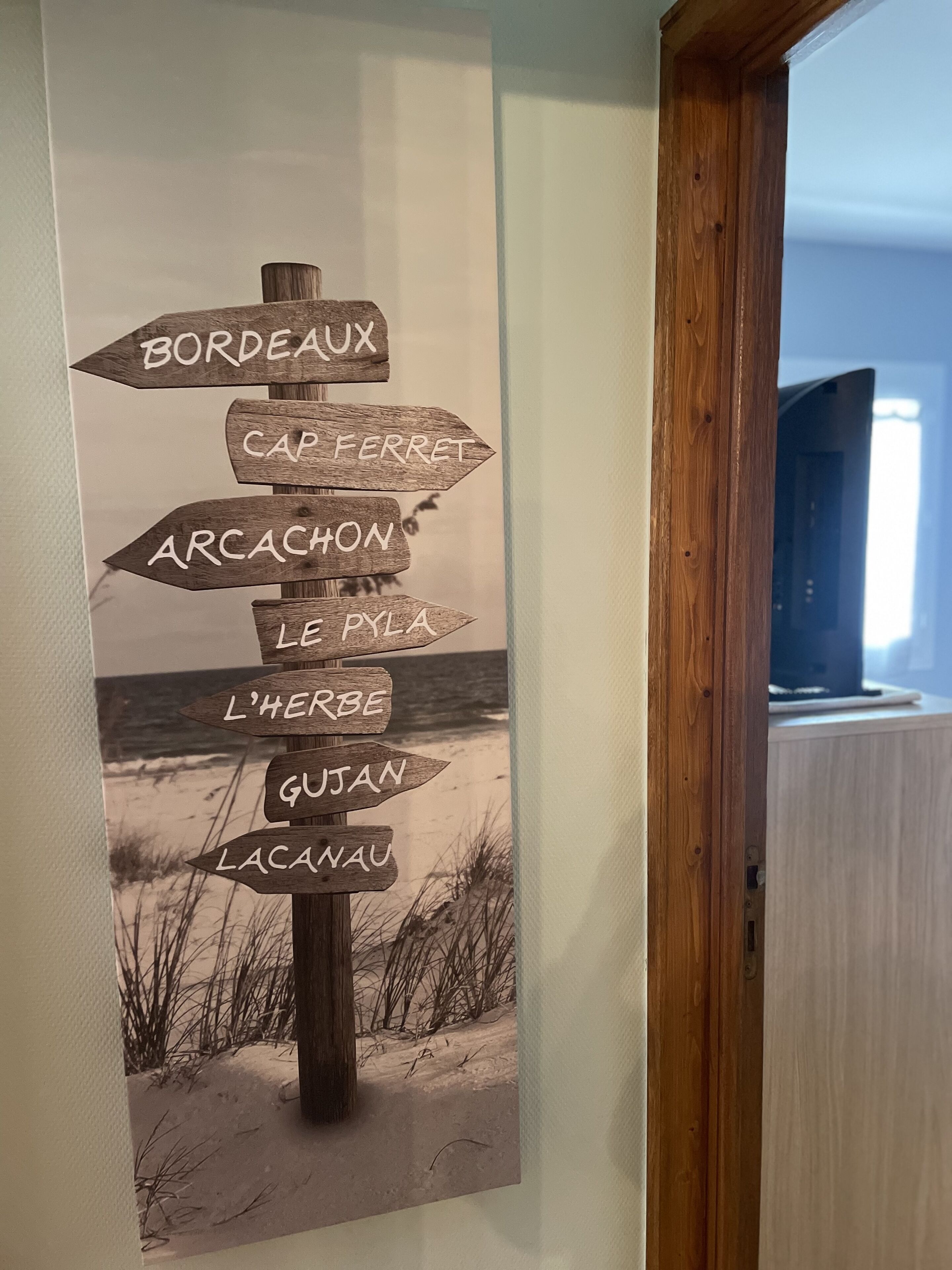 Señal en la pared con flechas direccionales que indican varios destinos en Francia.