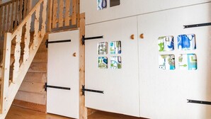 A staircase with wooden railings leading to a set of white lockers with colorful cut-out designs.