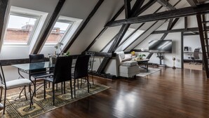 Une pièce de style loft comprenant un coin repas, un canapé et un téléviseur.