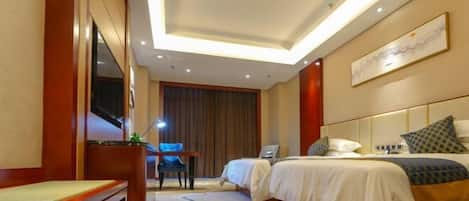 A hotel room with a bed, a desk, a chair, and a TV.