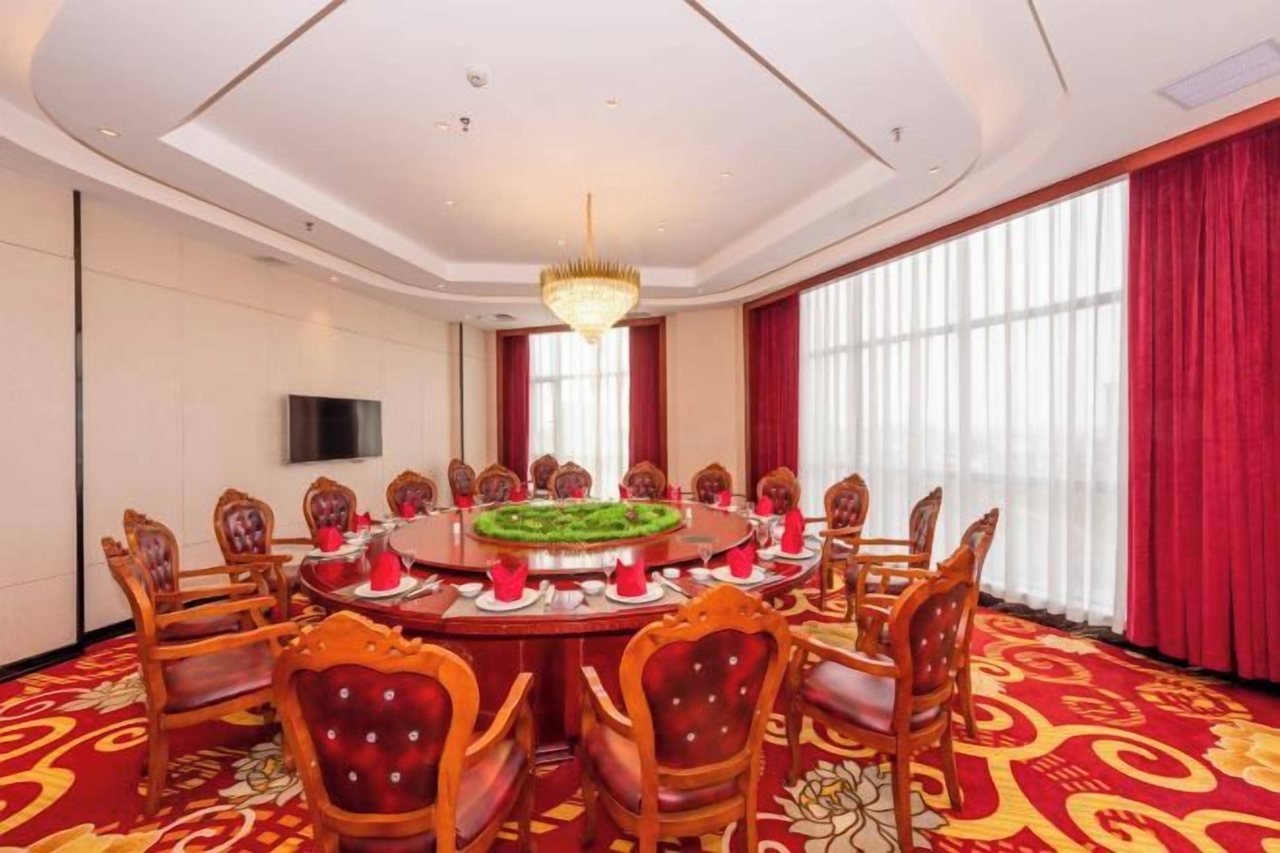 A conference room with a round table, chairs, and a chandelier.