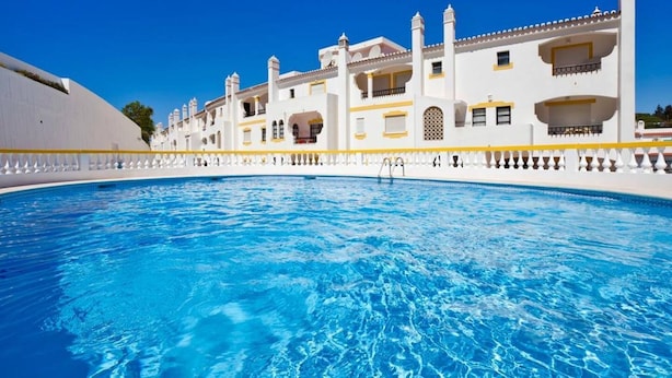 A swimming pool with a white building in the background. - Sunny Duplex W/ Pool & Balcony by LovelyStay (Carvoeiro)
