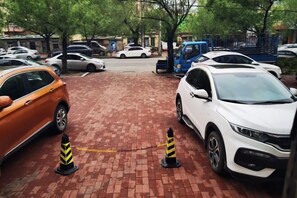 A parking area with cars, a brick pathway, and bollards. - AI SHANG Couples fheme hotel (Zhaodong)