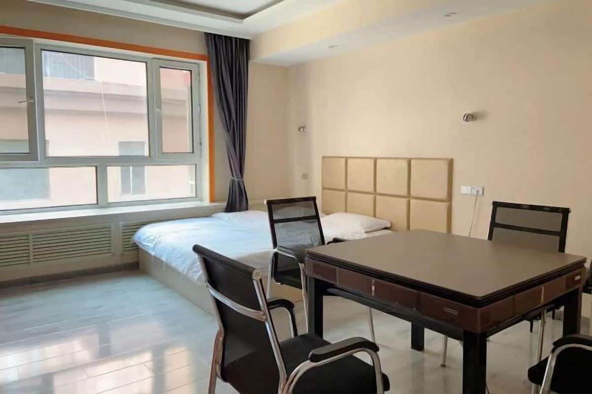A hotel room with a bed, a desk, and two chairs.