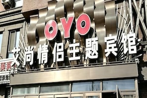 Un bâtiment arborant une enseigne « OYO » bien visible et des caractères chinois indiquant qu’il s’agit d’un hôtel.