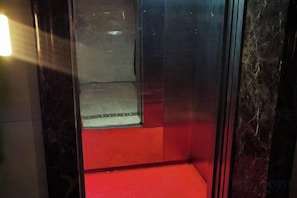 An elevator interior with a red floor and a metallic wall. - AI SHANG Couples fheme hotel (Zhaodong)