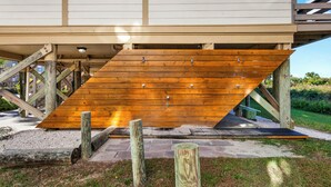 A wooden deck with a ramp leading to a building entrance. - 2-bedroom 2 bath condo at Lighthouse Point (Tybee Island)
