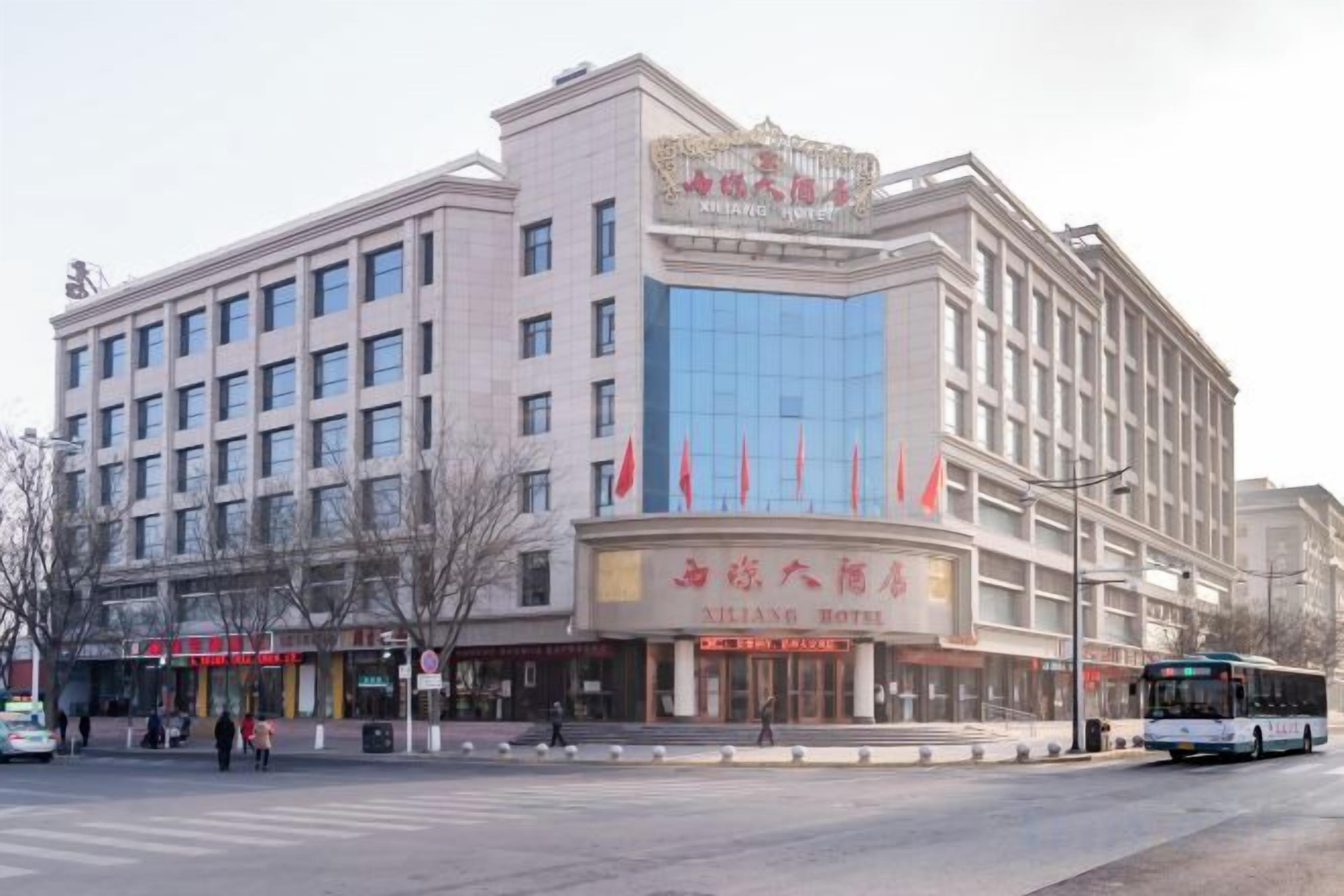 A multi-story hotel with a prominent entrance, a large glass facade, and a sign indicating it is a hotel.