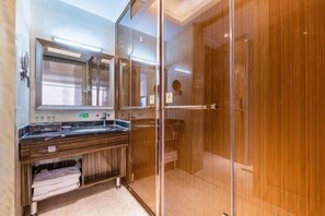 A modern bathroom with a glass shower enclosure, a vanity with a mirror, and a towel rack. - Xiliang Hotel (Wuwei)