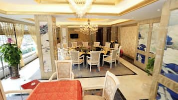 A dining area with a round table, chairs, and a chandelier.