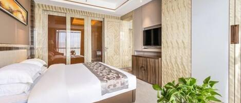 Una habitación de hotel moderna con una cama grande, un televisor, una planta y un armario.