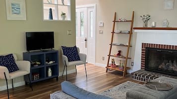 TV connectée, cheminée, table de tennis de table, livres