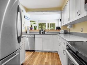 Enjoy cooking in this well-equipped kitchen with a refrigerator, oven, and ample cabinetry.
