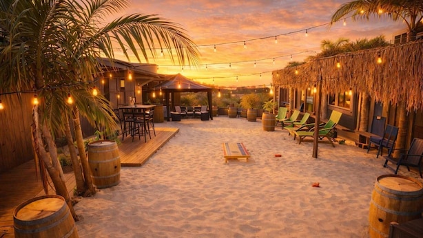 A beachside patio with wooden furniture, string lights, and palm trees. - Event Space: Beach Club with BBQ, Speakers & Great Vibes (San Diego)
