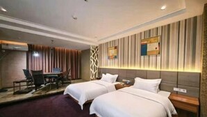 A hotel room with two beds, a desk, and a chair. - Dingrun Business Hotel (Huizhou)