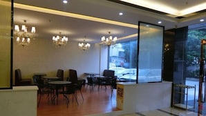A modern interior with a reception area, seating arrangements, and large windows offering a view outside. - Dingrun Business Hotel (Huizhou)