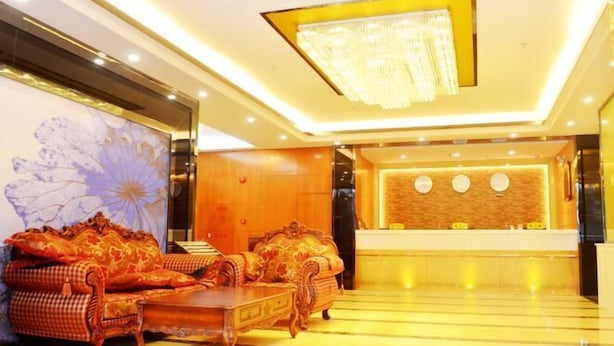 A lobby with ornate sofas, a reception desk, and a large floral artwork on the wall. - Dingrun Business Hotel (Huizhou)