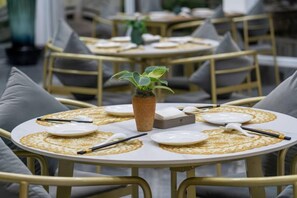 A dining area with round tables, each set with plates, cutlery, and a centerpiece. - Chuxiongzhou Hotel (Chuxiong City)
