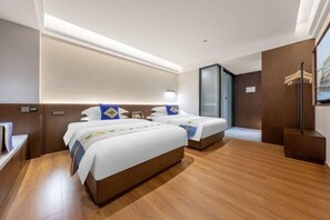 A hotel room with two beds, wooden flooring, a large mirror, and a television. - Chuxiongzhou Hotel (Chuxiong City)
