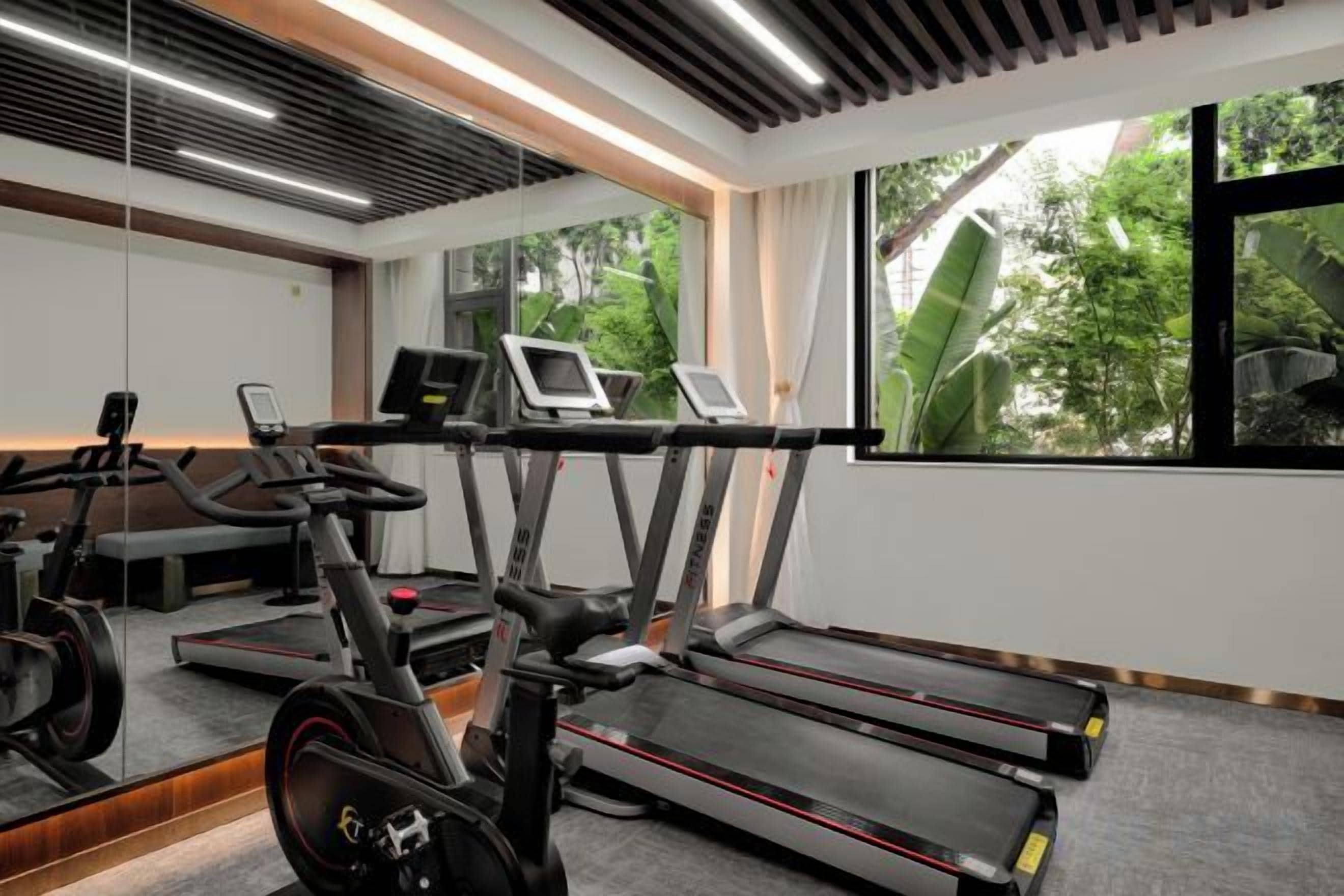A gym with treadmills, an elliptical, and a stationary bike.