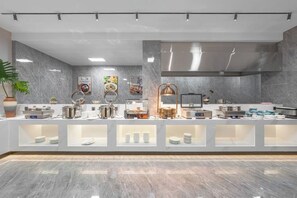 A modern kitchen with marble countertops, stainless steel appliances, and a variety of food items displayed. - Chuxiongzhou Hotel (Chuxiong City)