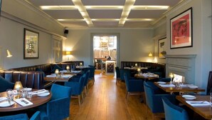 Un restaurant avec des banquettes et des tables, un plancher en bois et une allée centrale.