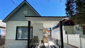 A single-story house with a front porch, a small staircase leading to the entrance, and a garage in the background.