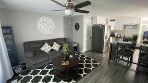 A living room with a grey sofa, a coffee table, and a ceiling fan.