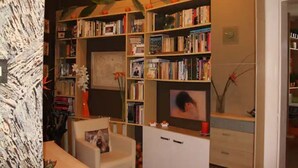 A room with a bookshelf filled with books, a television, and a small table with a chair. - Cosy & Spacious Apartment, City Center, WiFi FREE (Hlavní mesto Praha)