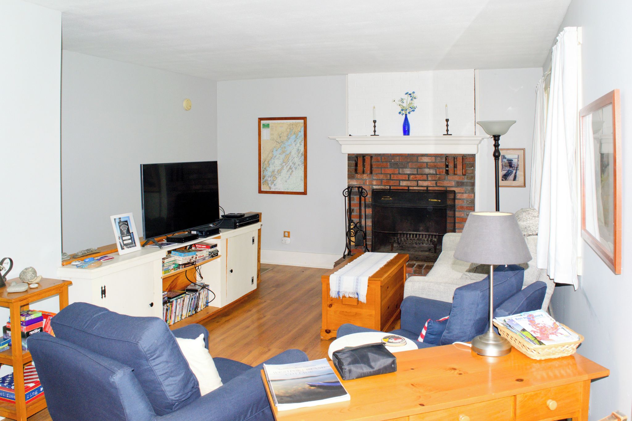 A living room with a television, a fireplace, and a bookshelf.