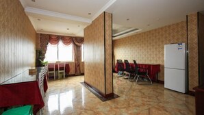 Habitación de hotel con una cama grande, una mesita de noche, un aparador y una ventana con cortinas.