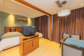 A hotel room with two beds, a TV, a desk, and a large window with curtains.