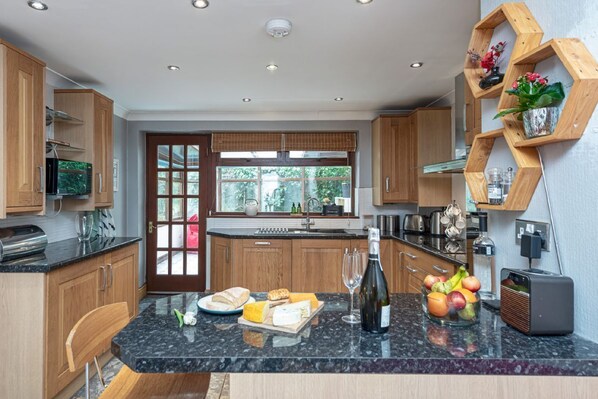 A modern kitchen with wooden cabinets, a granite countertop, and a built-in wine cooler.