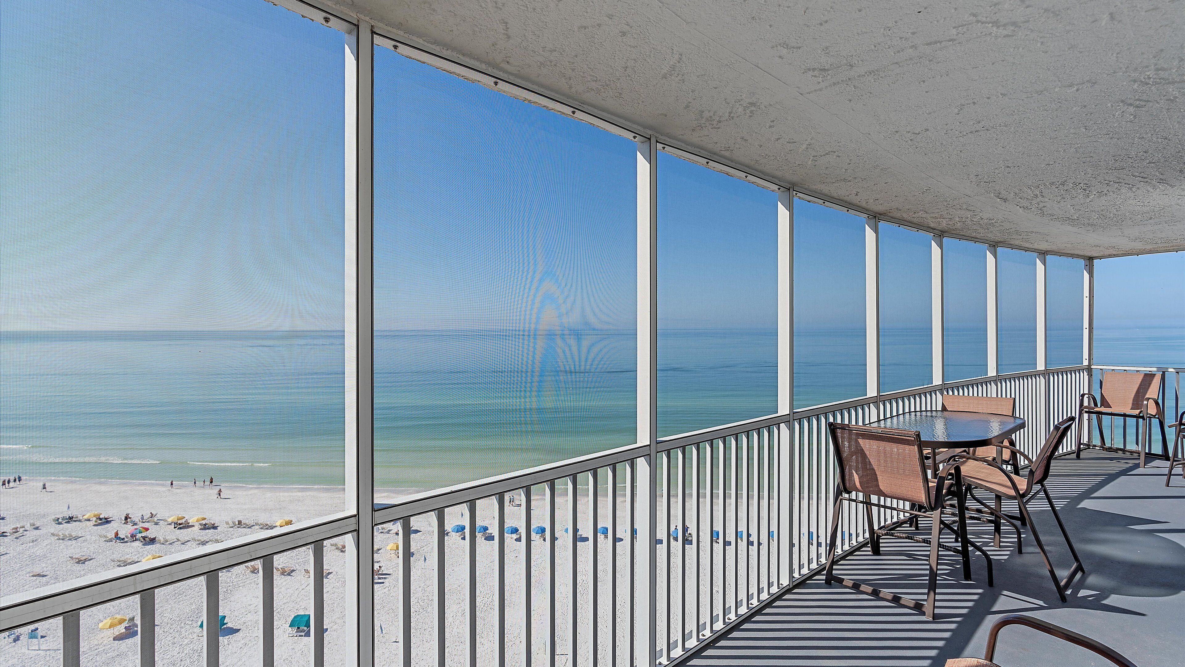 Un balcon avec vue sur la plage et l’océan.
