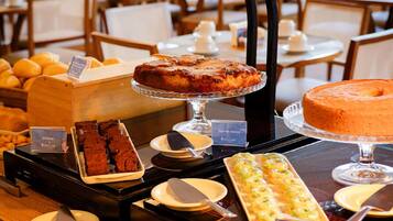 A buffet with various baked goods and desserts.