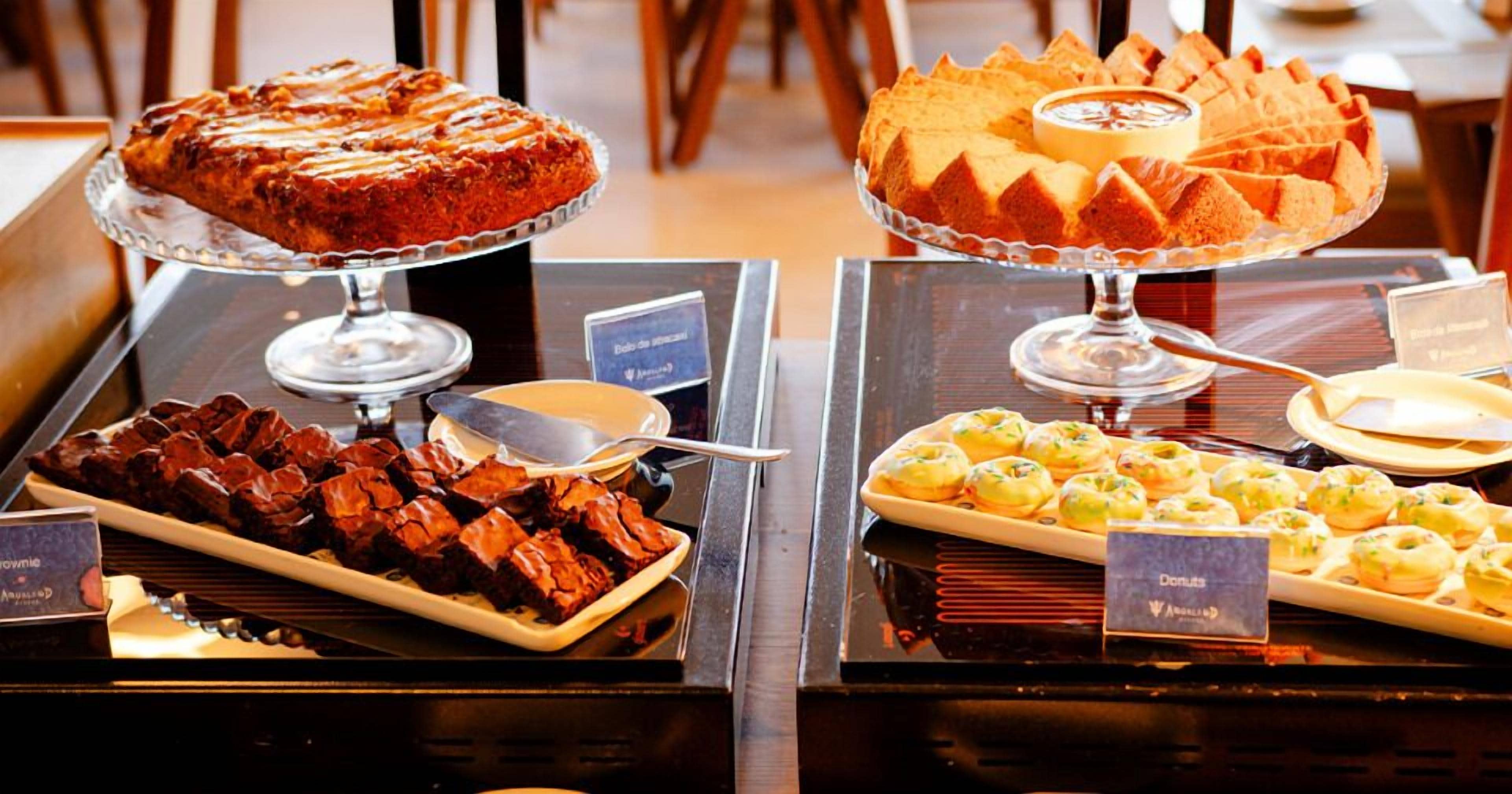 Un bufé con diversos postres, incluyendo pasteles y repostería.