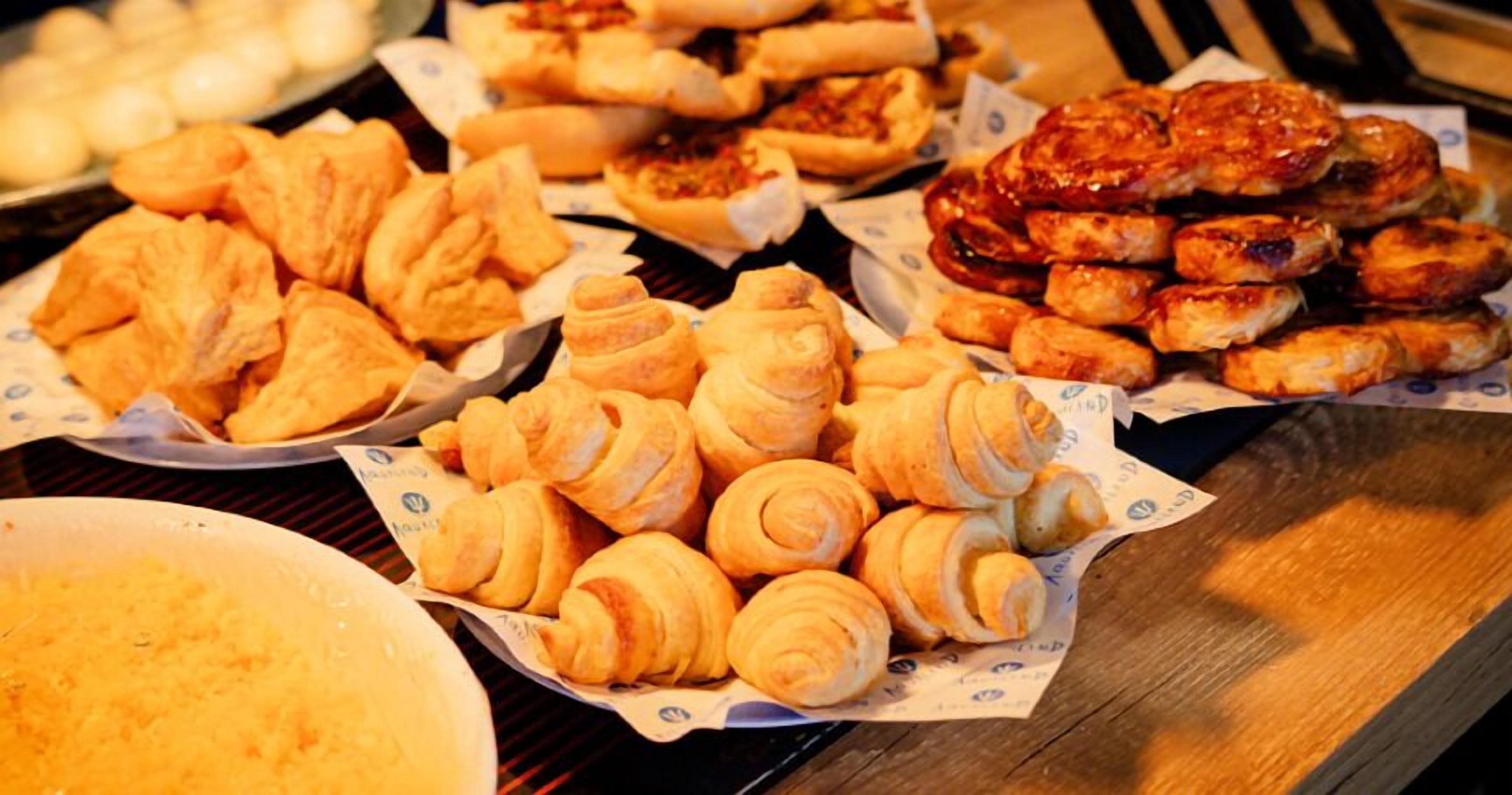 A variety of baked goods including pastries and bread on a wooden table.