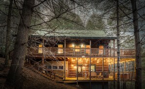 A two-story log cabin with a balcony, wooden stairs, and a porch area. - 2 acre secluded Retreat Private creek Spa Gameroom (Morganton)