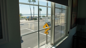 Une vue à travers une fenêtre, avec un panneau de signalisation indiquant un passage piéton et un panneau indiquant qu'il est interdit de bloquer l'intersection.