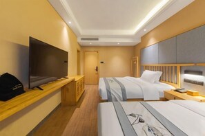 Una camera d'albergo con due letti, una televisione, una scrivania e un armadio.