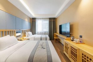 A hotel room with two beds, a TV, a wooden console table, and a large window with curtains.