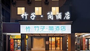 The exterior of Bamboo Hotel with illuminated signage and a modern facade.