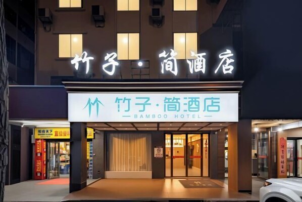 The exterior of Bamboo Hotel with illuminated signage and a modern facade.