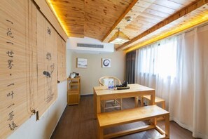 A room with a wooden ceiling, a wooden table with benches, a chair, and a window with curtains. - zhuzijianHotel (Yueyang)