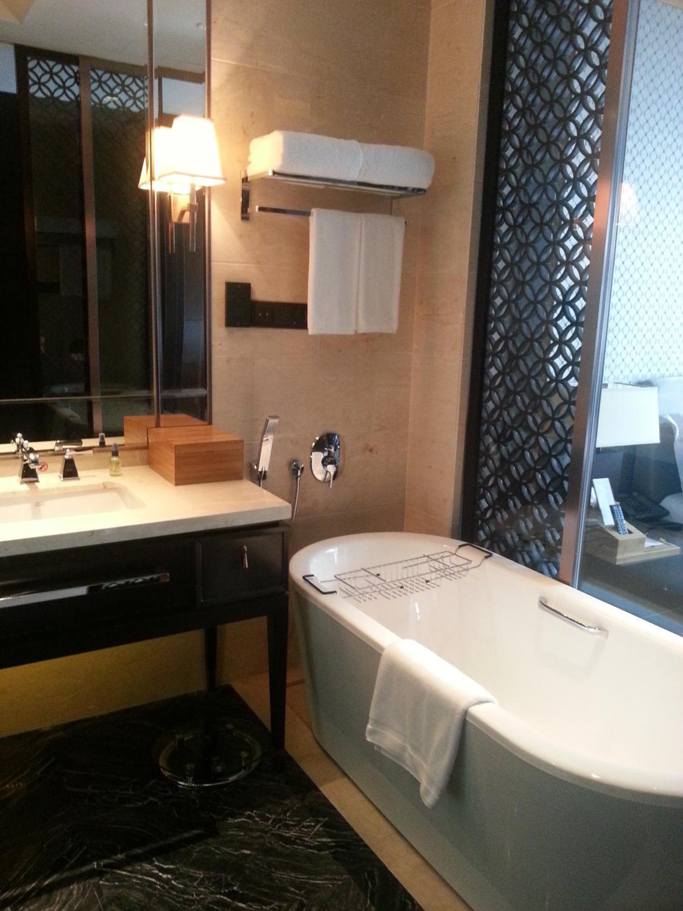 A modern bathroom with a bathtub, a sink, and a mirror.