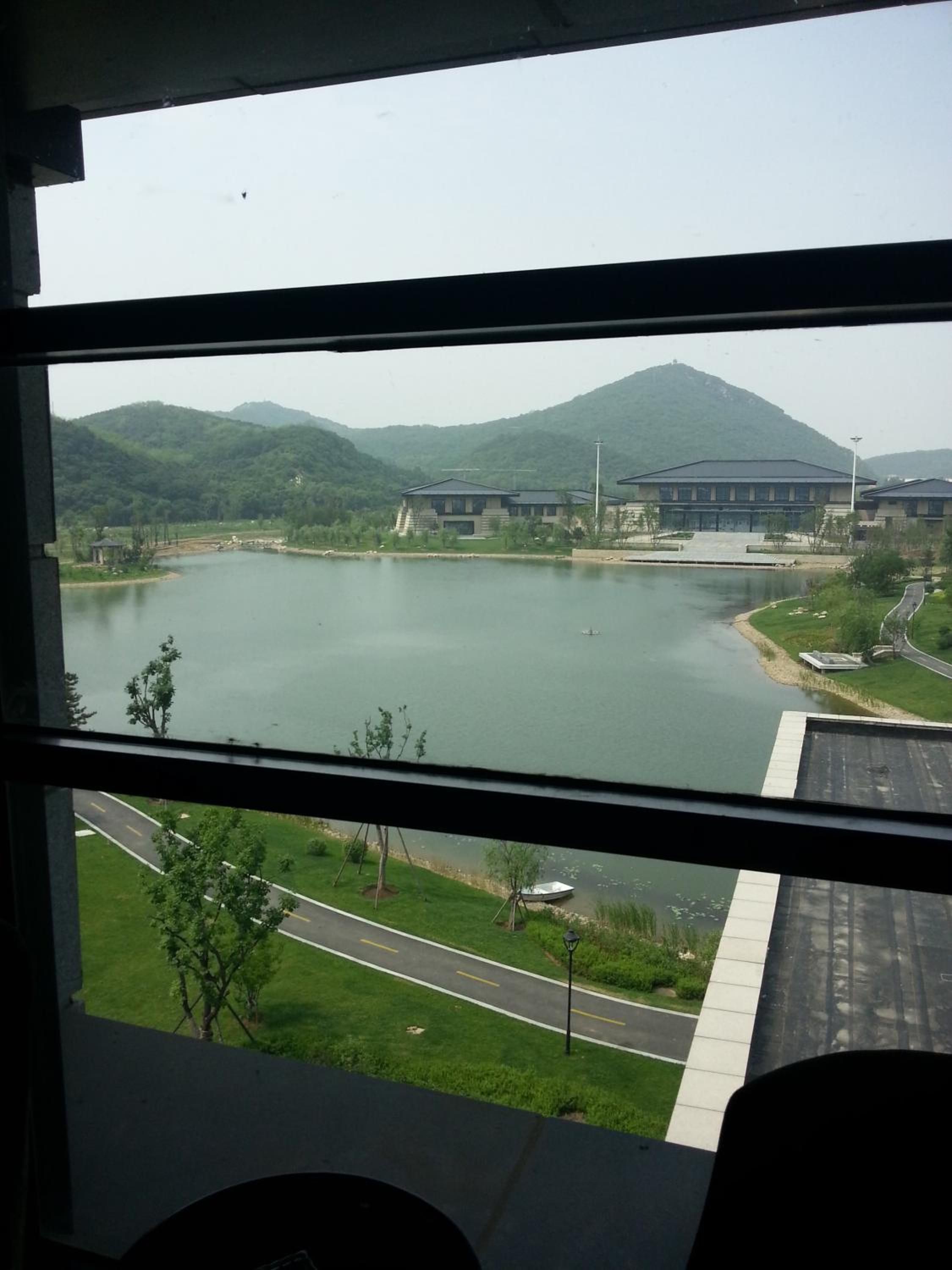 Vista de un lago con edificios y una montaña al fondo.